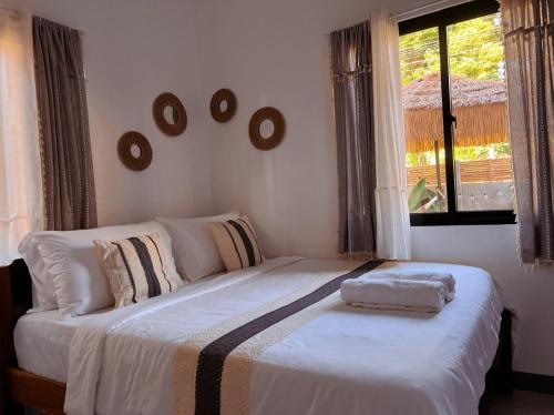 a bedroom with a white bed with a window at Liminaya Villa in El Nido