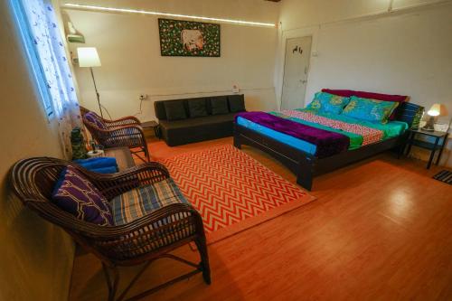 a living room with a bed and a couch at Home Stay in Arogyam at Mulshi Backwaters in Mulshi