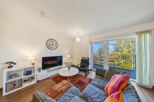 a living room with a couch and a tv at Stylish long & short stay flat with parking & Wifi sleeps 5 in Maidstone