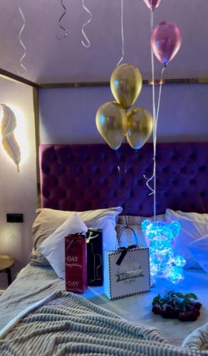 a bed with balloons and gifts on top of it at Aura Spa Oberhausen Premium in Oberhausen