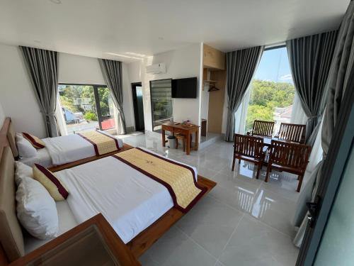 a hotel room with two beds and a television at Villa caribe phu quoc in Phú Quốc
