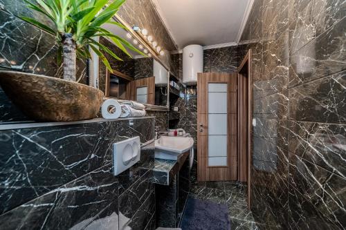 a bathroom with a sink and a potted plant at Villa Mart in Zadar
