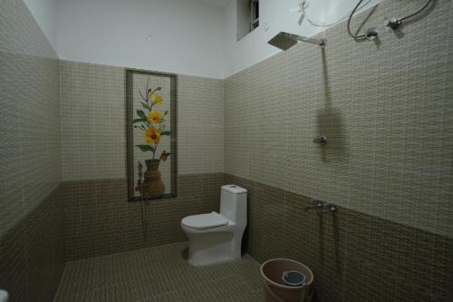 a bathroom with a toilet and a shower at YR sea resort in Pāmban