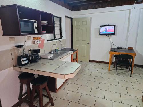 a kitchen with a counter and a sink and a television at Apartamento 9 Tec in Cartago