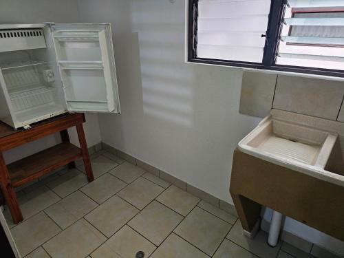 a small kitchen with a refrigerator and a sink at Apartamento 9 Tec in Cartago