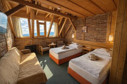 a room with two beds and a chair in a building at Josefova Bouda -Resort Svaty Frantisek in Špindlerův Mlýn