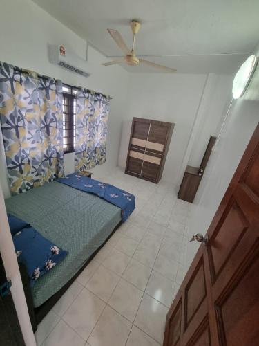 a bedroom with a blue bed in a room at D' Saras Homestay in Sitiawan
