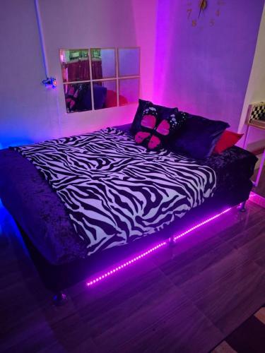 a bed with a zebra blanket and lights on it at Ciel's Deluxe Haven in Binangonan
