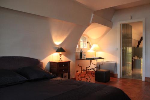 a bedroom with a bed and a table with lamps at La Bonne Auberge - Seine Panorama SAS in Vieux-Port
