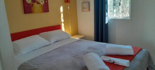 a bedroom with a large bed with two towels on it at Blue Flower Cottage in Lightning Ridge