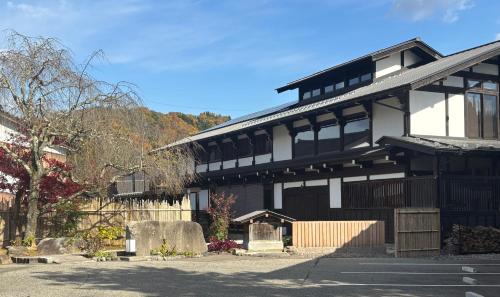 a black and white building with a cemetery in front of it at Onsen and Garden Nana in Kanazawa
