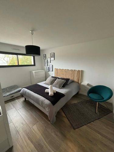 a bedroom with a large bed and a blue chair at Villa Ty Varcq in Locquirec