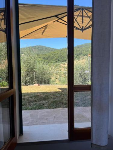 an open glass door with a view of a yard at Costa Del Sole 48 in Camporsevoli
