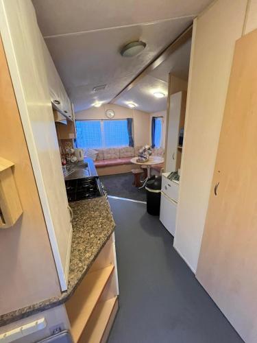 an empty kitchen and living room in an rv at Seawick Beach Caravan in Saint Osyth