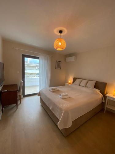 a bedroom with a bed and a desk and a window at The Costa Suite byArtistunknown in Vari