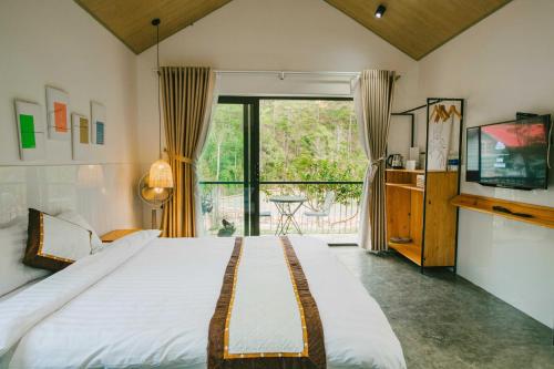 a bedroom with a large bed and a large window at Shanti Wellness Sanctuary Đà Lạt in Da Lat