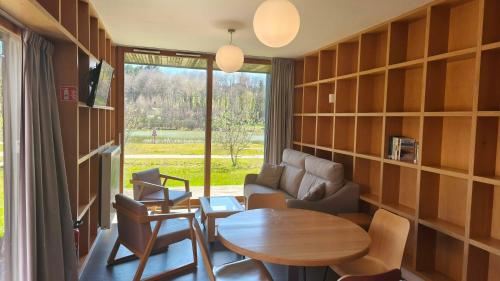 a room with a table and chairs and a large window at Les Woodies in Xertigny