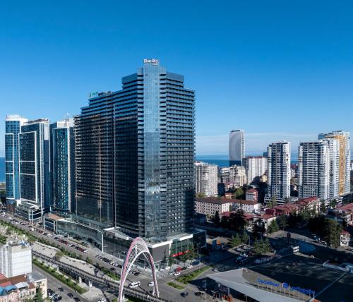 a city with a tall building and a ferris wheel at Blue Sky Apart-Hotel Batumi in Batumi