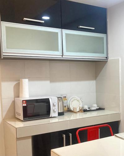 a microwave sitting on a counter in a kitchen at UrbaNest WCY in Wakaf Che Yeh