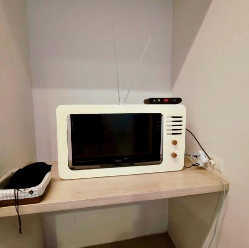 a microwave sitting on top of a shelf at Ena Boutique Hotel & Cafe in Chiang Mai