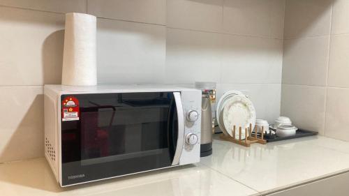 a microwave sitting on a counter in a kitchen at UrbaNest WCY in Wakaf Che Yeh