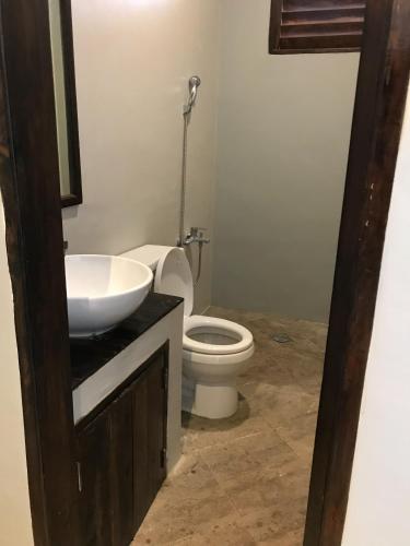 a bathroom with a white toilet and a sink at jbsurf House in Catagnan
