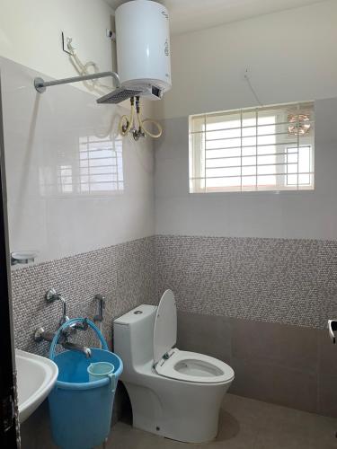 a bathroom with a toilet and a sink at XD Hotels 101 in Bangalore