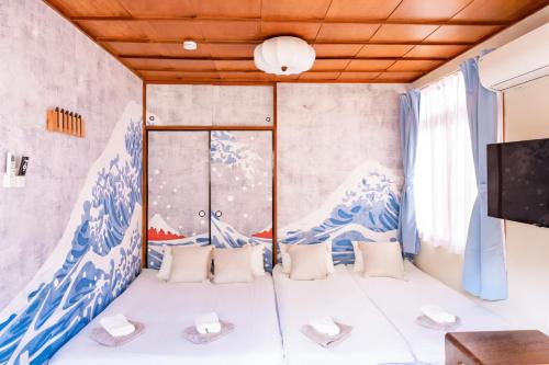 a room with a wave mural on the wall at Court Ada -1min to Araiyakushi-mae Station, 9min train to Shinjuku- 新井薬師前駅徒歩50秒 in Tokyo