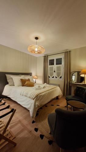 a bedroom with a large white bed and a chandelier at LUCIA AL MARE - chambre d'hôtes in Châtelaillon-Plage