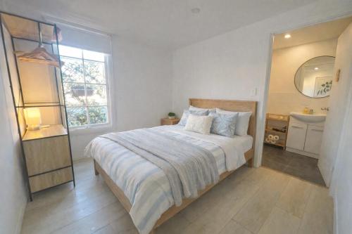 ein Schlafzimmer mit einem großen Bett und einem Waschbecken in der Unterkunft Rustic PepperTree Views in Rockingham