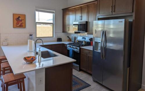 a kitchen with a stainless steel refrigerator and wooden cabinets at Cozy Southwest Style Hideaway with Mountain Views in Phoenix