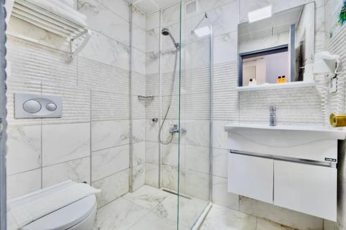 a bathroom with a shower and a toilet and a sink at Hanedan Beach Hotel in Foça