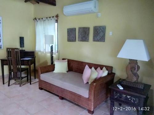 a living room with a couch and a table with a lamp at Sea World Club Beach Resort & Dive Center in Maumere