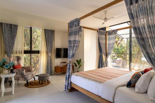 a bedroom with a large bed and a window at Lindsay Manor Santo Sovrano 4BHK Heated Pool in Vagator