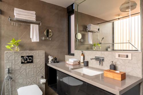 a bathroom with a sink and a mirror at Lindsay Manor Santo Sovrano 4BHK Heated Pool in Vagator