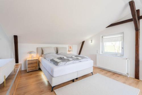 a white bedroom with a bed and a window at Ferienhaus Achtern Diek in Hemme