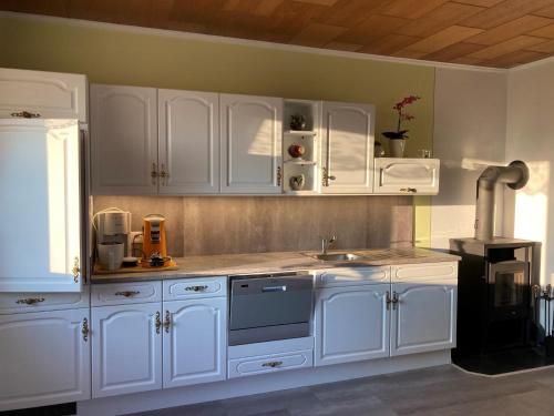 a kitchen with white cabinets and a sink at Huber Hof in Oberrosenauerwald