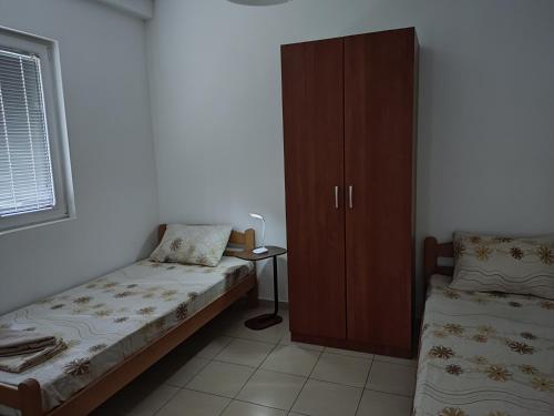 a small bedroom with a bed and a cabinet at Villa Zora in Star Dojran