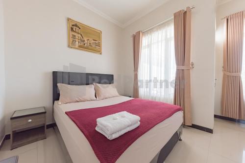 a bedroom with a large bed with a red blanket at Wisma Brata 2 Mitra RedDoorz in Nyomolong