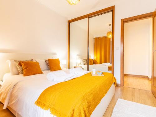 a bedroom with a large bed with a yellow blanket on it at Apartment in Oeiras Near Beach Easy Access Lisbon Cascais in Oeiras