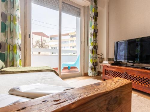 a bedroom with a tv and a large window at Apartment in Oeiras Near Beach Easy Access Lisbon Cascais in Oeiras