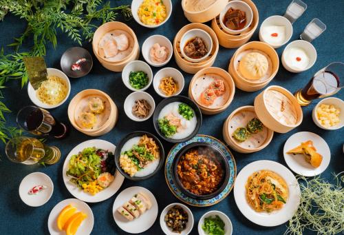 a table with plates of food and bowls of food at Koraku Garden Hotel Tokyo in Tokyo