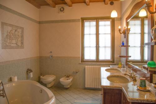 a bathroom with two sinks and a tub and a toilet at Mulino di Prada in Lodi