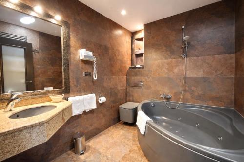 a bathroom with a tub and a sink and a mirror at La Posada d'Àneu by RdA Hotels in Esterri d'Àneu