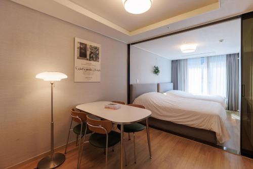 a room with a bed and a table and a bed at WECO STAY Myeongdong in Seoul