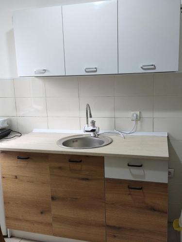 a kitchen with a sink and white cabinets at Villa Zora in Star Dojran