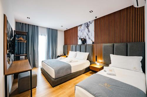 a hotel room with two beds and a television at Hotel Siars in Ksamil