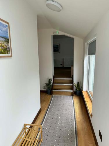 a hallway with a bench and stairs in a building at 1 Manse Lane in Portree