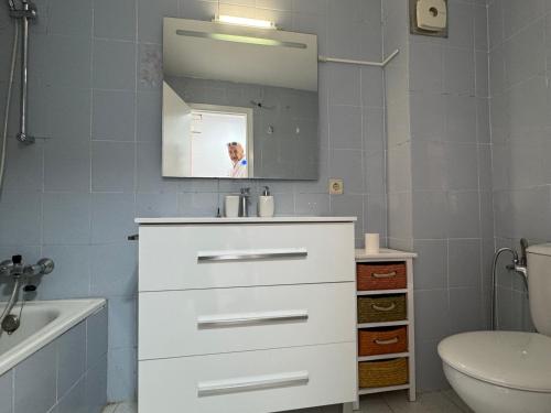 ein Badezimmer mit einem weißen Waschbecken und einem Spiegel in der Unterkunft Punta Atico in Alcanar