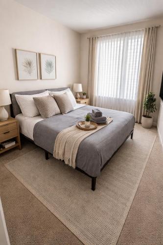 a bedroom with a large bed with a tray on it at Modern 1 & 2 Bedroom Apartments Near Venice & MDR with Pool Gym & Cinema in Los Angeles